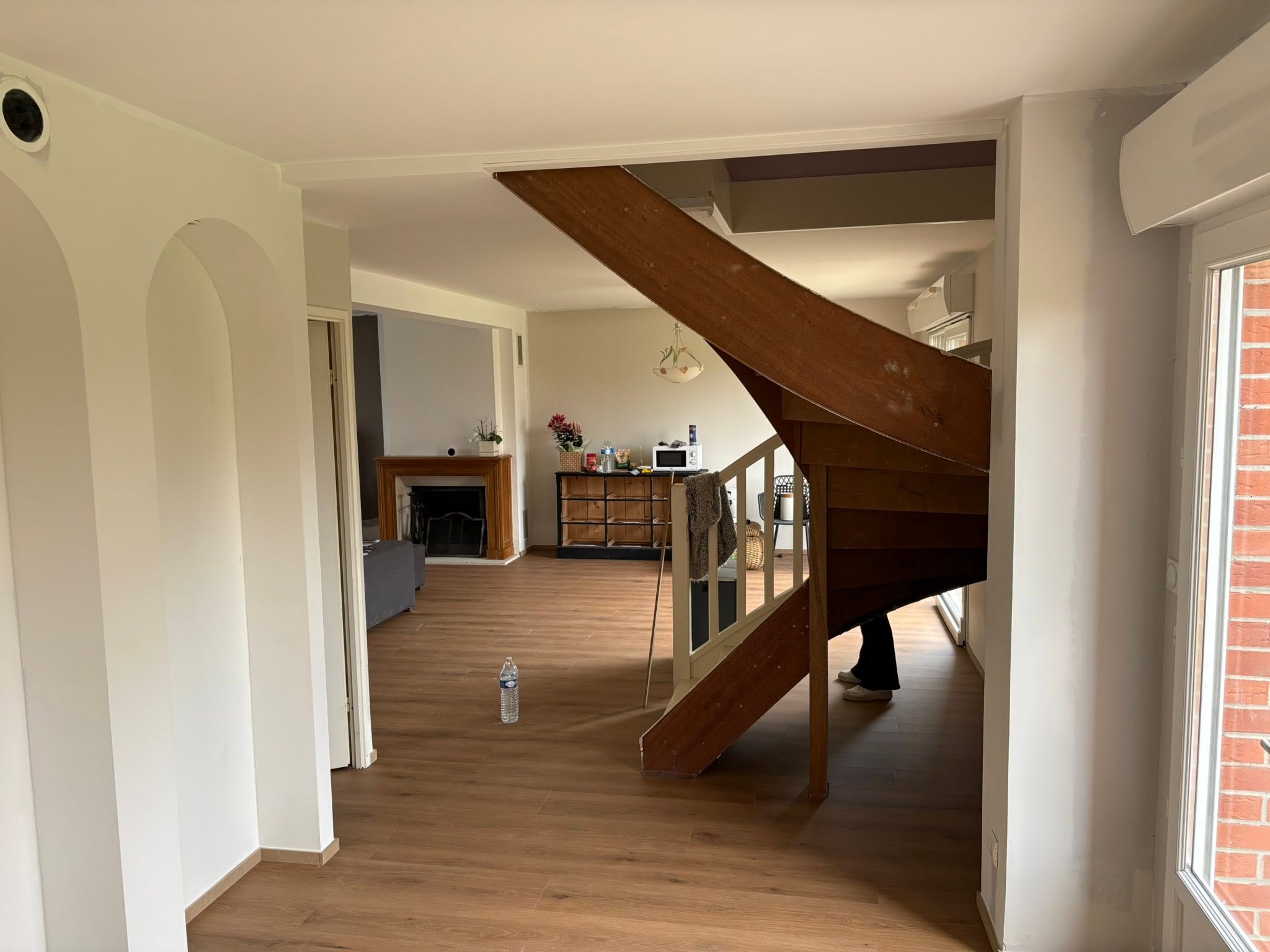 Séjour rénové avec escalier en bois et parquet neuf